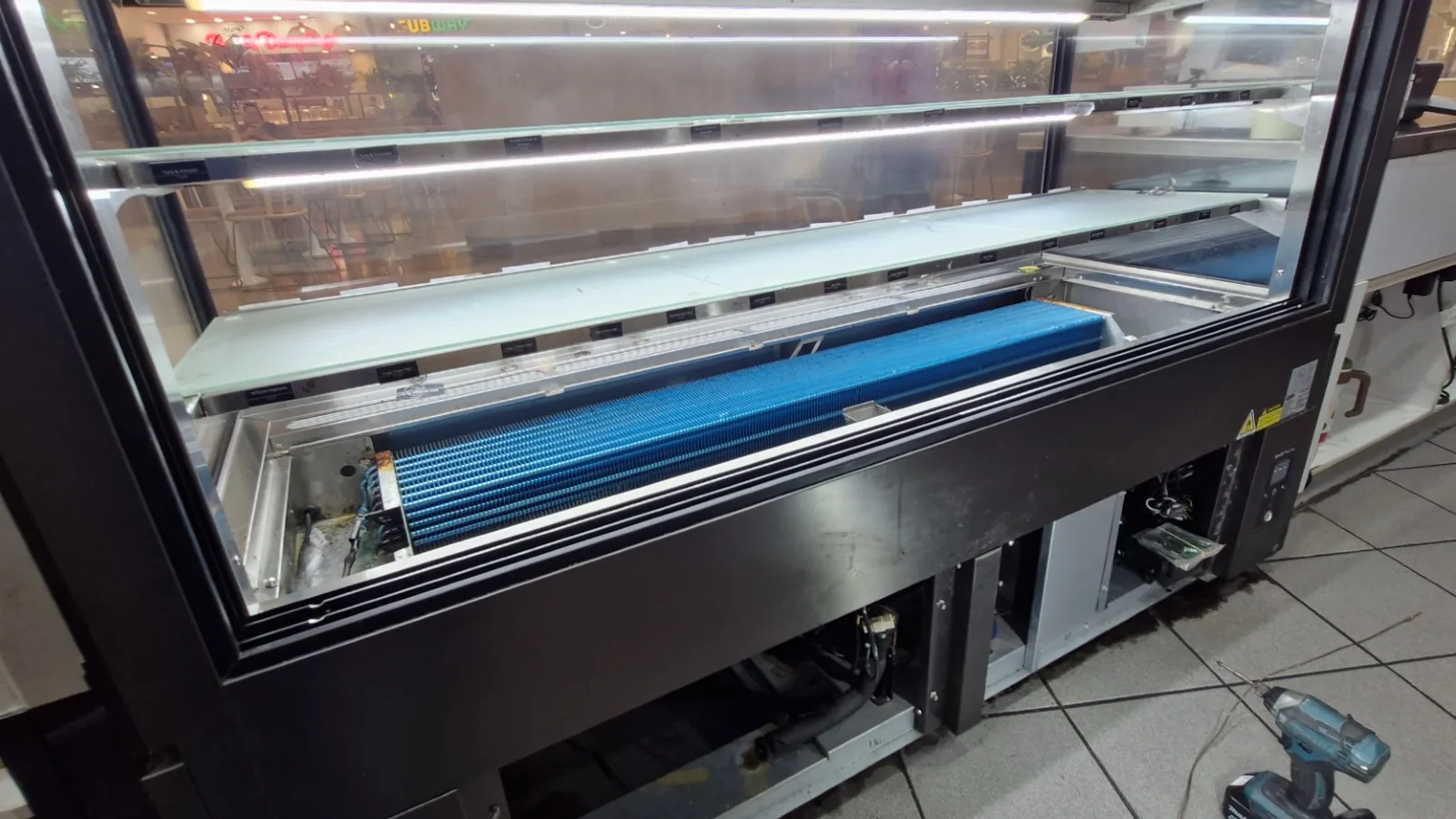 Commercial refrigerated display case being serviced by Climatec Solutions NQ